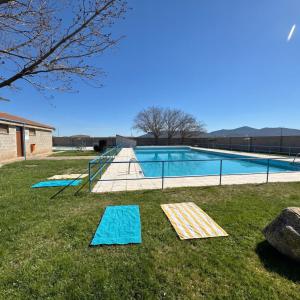 a swimming pool with blue mats in the grass at Casa rural La abuela in Mainar