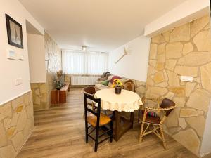 a dining room with a table and a stone wall at Casa rural La abuela in Mainar