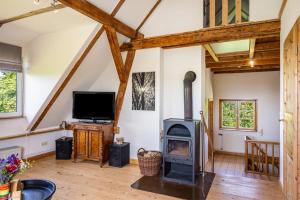 a living room with a wood stove and a tv at Forsthof Schulte in Pronstorf