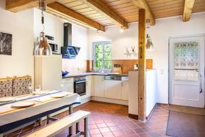 a kitchen with white cabinets and a table with chairs at Forsthof Schulte in Pronstorf