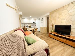 a living room with a couch and a flat screen tv at Casa rural La abuela in Mainar