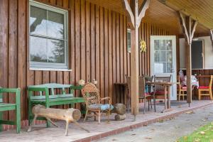 a wooden house with tables and chairs on a porch at Großes Gästehaus in Sudwalde