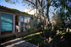 a house with a screened porch and a tree at Villa Arbre de Vie in La Crau +9 photos