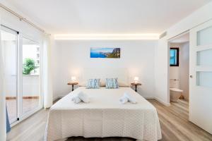 a white bedroom with a large white bed with two pillows at Albercutx Pollentia 1 2 3 in Pollença