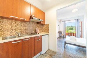 a kitchen with wooden cabinets and a sink at Arianna Studio Ground Floor 3 in Paleokastritsa