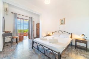 a white bedroom with a bed and a balcony at Arianna Studio Ground Floor 3 in Paleokastritsa