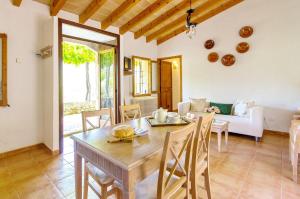 a dining room with a table and a couch at Na Garrovera in Pollença