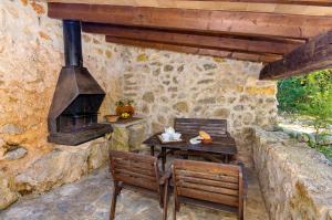 a patio with a table and chairs and a stove at Na Garrovera in Pollença
