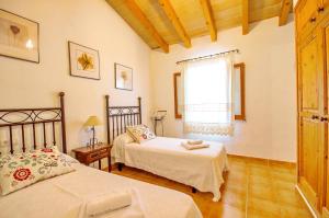 a bedroom with two beds and a window at Na Garrovera in Pollença +20 photos
