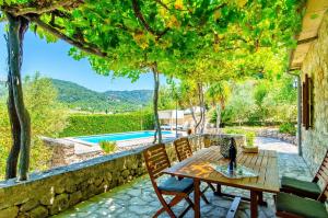 a patio with a table and chairs and a pool at Na Garrovera in Pollença