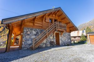 a log cabin with a staircase on the side of it at Chalet Le Chastel in Pelvoux