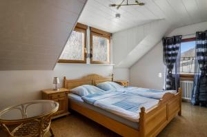 a bedroom with a bed and a chair and windows at Ferienwohnung Maria in Liggersdorf