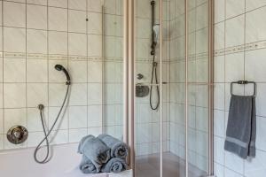 a bathroom with a shower and a tub with towels at Ferienwohnung Maria in Liggersdorf +21 photos