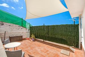a patio with a fence and a table and chairs at Casa Bene in Güimar