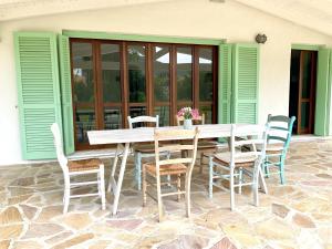 a wooden table and chairs on a patio at Villa Alzoni in San Teodoro