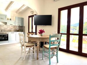 a kitchen with a table with chairs and a tv at Villa Alzoni in San Teodoro +36 photos