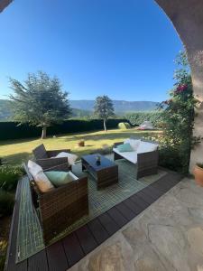 a patio with couches and a table on a deck at Chambre D'hôtes La Grande Calade in Lagrand