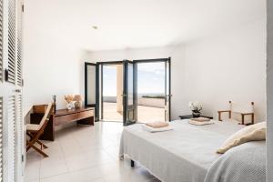 a white bedroom with two beds and a balcony at Villa Es Gallinots in Mahón +28 photos