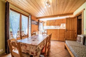 a dining room with a table and a kitchen at Apt Chénives 1 - Morzine in Morzine