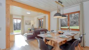 a dining room and living room with a table and chairs at Waldfee - Stilvolles Ferienhaus in Kemmerode