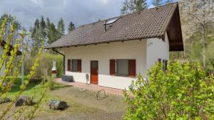 a small white house with a brown roof at Waldfee - Stilvolles Ferienhaus in Kemmerode