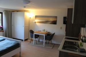 ein kleines Zimmer mit einem Tisch und einer Küche in der Unterkunft Am Barthelwald in Wilhelmsdorf