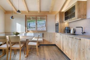 a kitchen with wooden cabinets and a table and chairs at Chalet Hugo in Verano