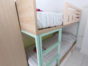 a bunk bed in a room with a shelf with pillows at R-06 Holiday Apartment La Mata in La Mata