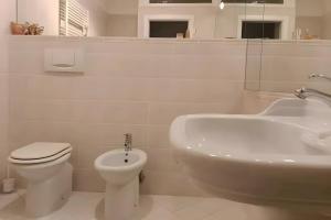 a white bathroom with a sink and a toilet and a tub at Residenza sul Livenza in Sacile +22 photos
