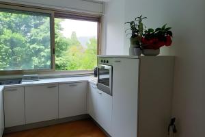 a kitchen with white cabinets and a window at Residenza sul Livenza in Sacile