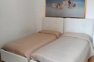 two beds in a room with a picture on the wall at Residenza sul Livenza in Sacile