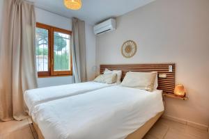 a bedroom with a large bed with white sheets at Villa Pura Vida by Easy Brava in Calonge +19 photos