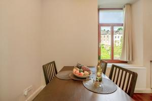 a dining room table with a bowl of fruit and a window at Alte Stadtvilla am Weinberg 2 in Traben-Trarbach