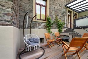 a porch with rocking chairs and a swing at Alte Stadtvilla am Weinberg 2 in Traben-Trarbach
