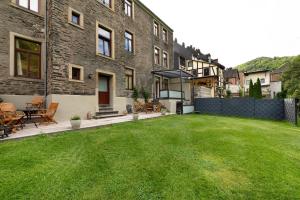 a backyard of a building with a grass yard at Alte Stadtvilla am Weinberg 2 in Traben-Trarbach