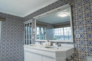 a bathroom with a white sink and a mirror at Douro Garden Home Rooftop in Vila Nova de Gaia +27 photos