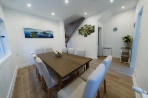 a dining room with a wooden table and white chairs at Douro Garden Home Rooftop in Vila Nova de Gaia