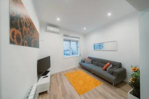a living room with a couch and a television at Douro Garden Home Rooftop in Vila Nova de Gaia