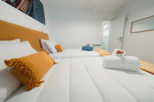 a white room with two white couches and yellow pillows at Douro Garden Home Rooftop in Vila Nova de Gaia