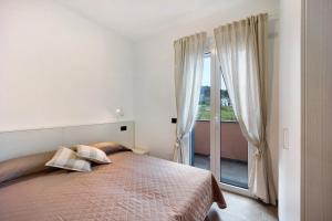 a bedroom with a bed and a large window at Antichi Ricordi - Il Nido in Marina di Andora