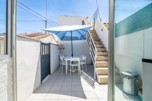 a balcony with a table and an umbrella at Maison de pecheurs in Valras-Plage