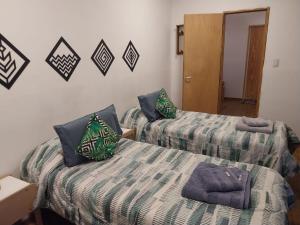 a room with two beds with pillows on them at Cerro Chaltén House - Deptos in El Chalten