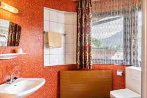 a bathroom with a sink and a toilet and a window at Pension Heidelberg in Hopfgarten im Brixental +178 photos