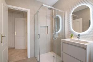 a bathroom with a shower and a sink and a mirror at Casa Valerie in Vale do Lobo +25 photos