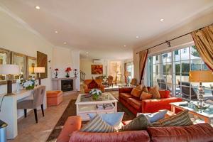 a living room with orange couches and a table at Casa Valerie in Vale do Lobo