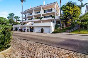 a large white building on the side of a street at Casa Valerie in Vale do Lobo