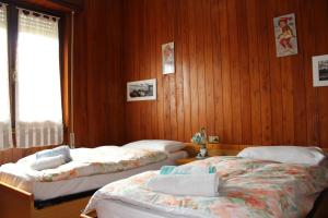 two beds in a room with wooden walls at Vista Lago Casa Demonti in Tignale +30 photos