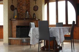 a dining room with a table and a fireplace at Vista Lago Casa Demonti in Tignale