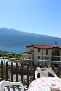 a table and chairs on a balcony with a building at Vista Lago Casa Demonti in Tignale