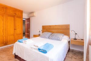a bedroom with a large white bed with blue towels on it at Casa Coronel Aloy in Pollença